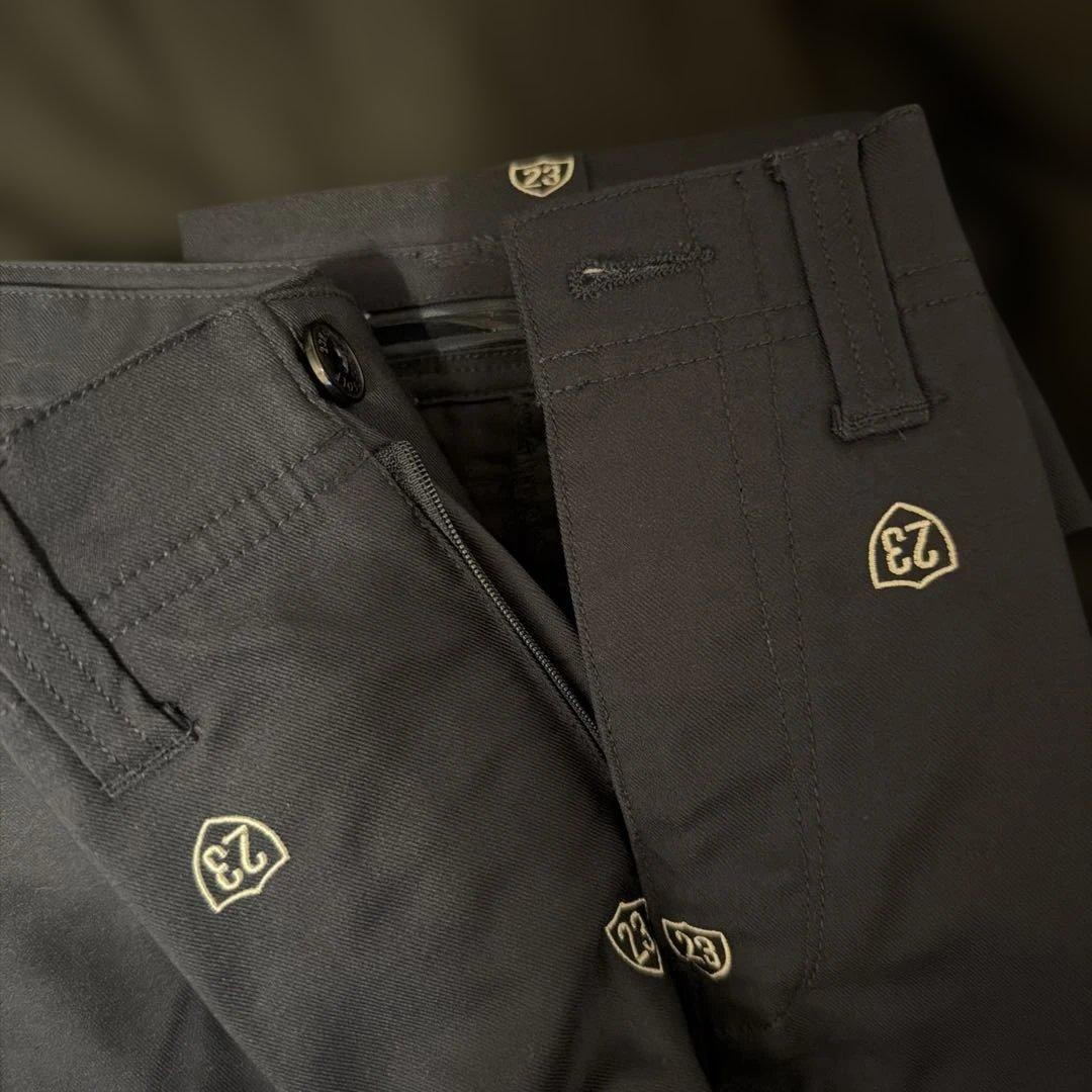 エンブレムデザインの黒いパンツ